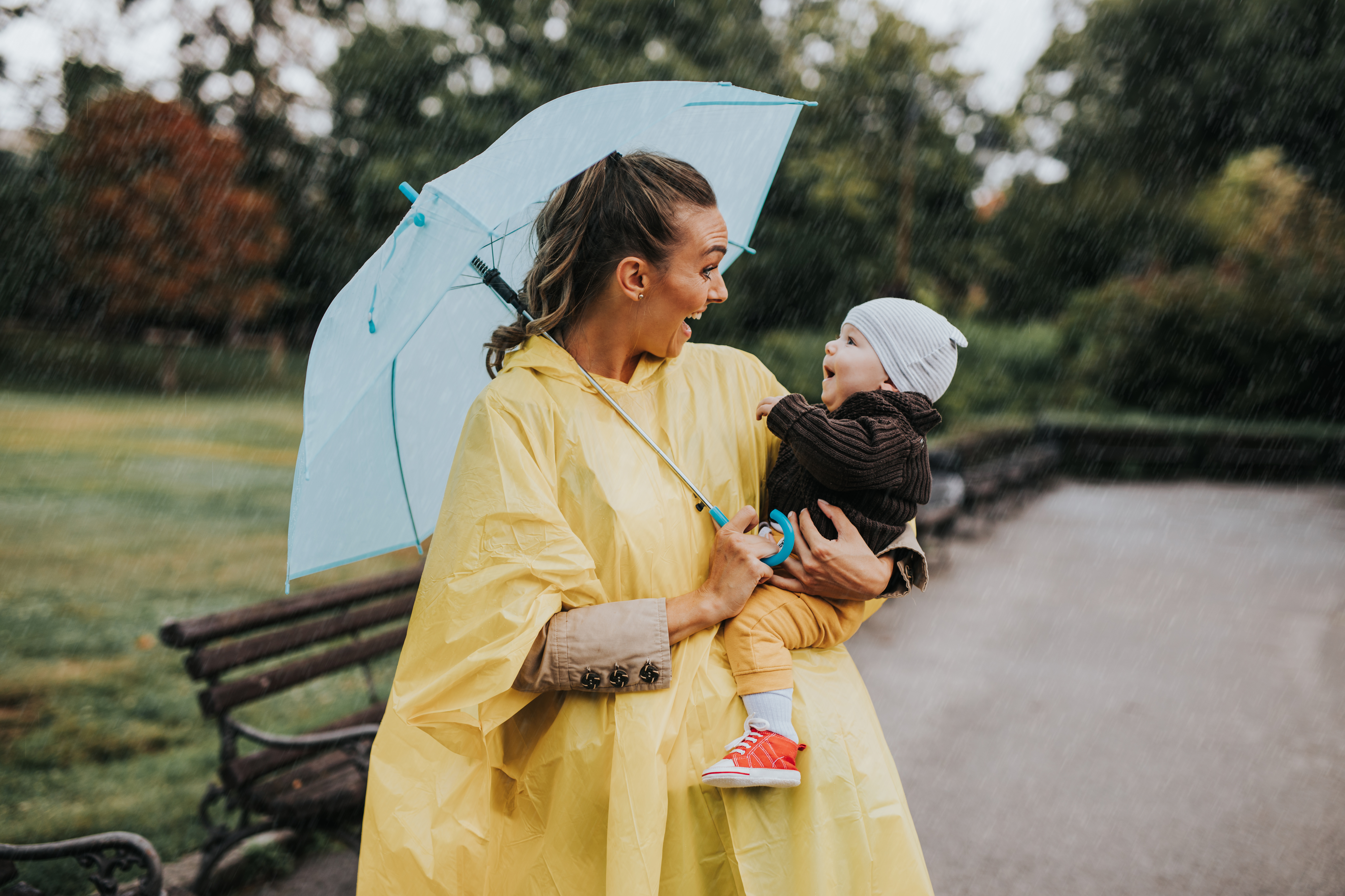 mother holding baby under umbrella
